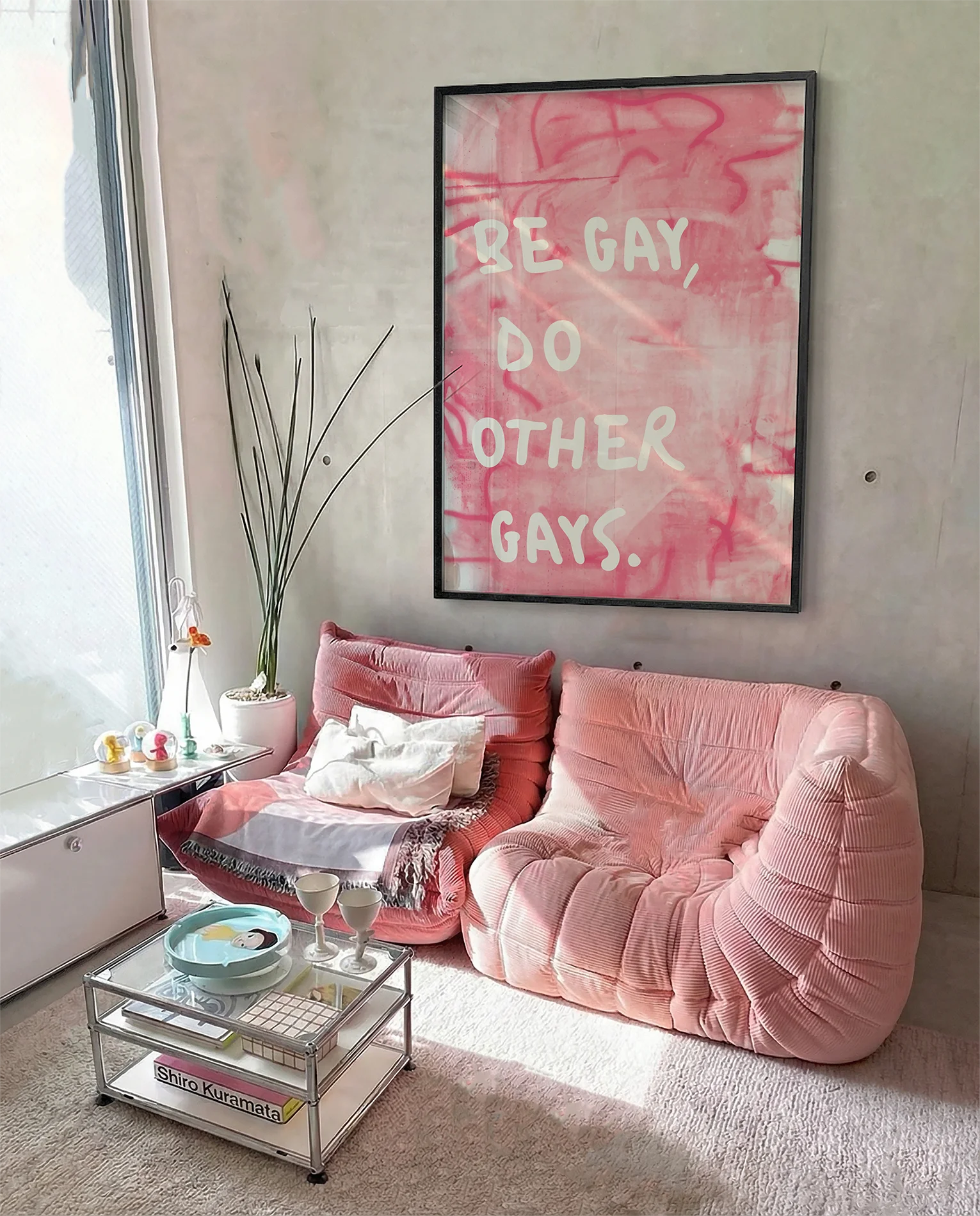 A framed poster with the text 'BE GAY, DO OTHER GAYS.', against a pink, abstract background.