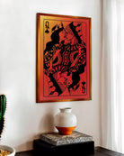 A poster with a sapphic couple kissing, card deck style. Two queens. Red background.