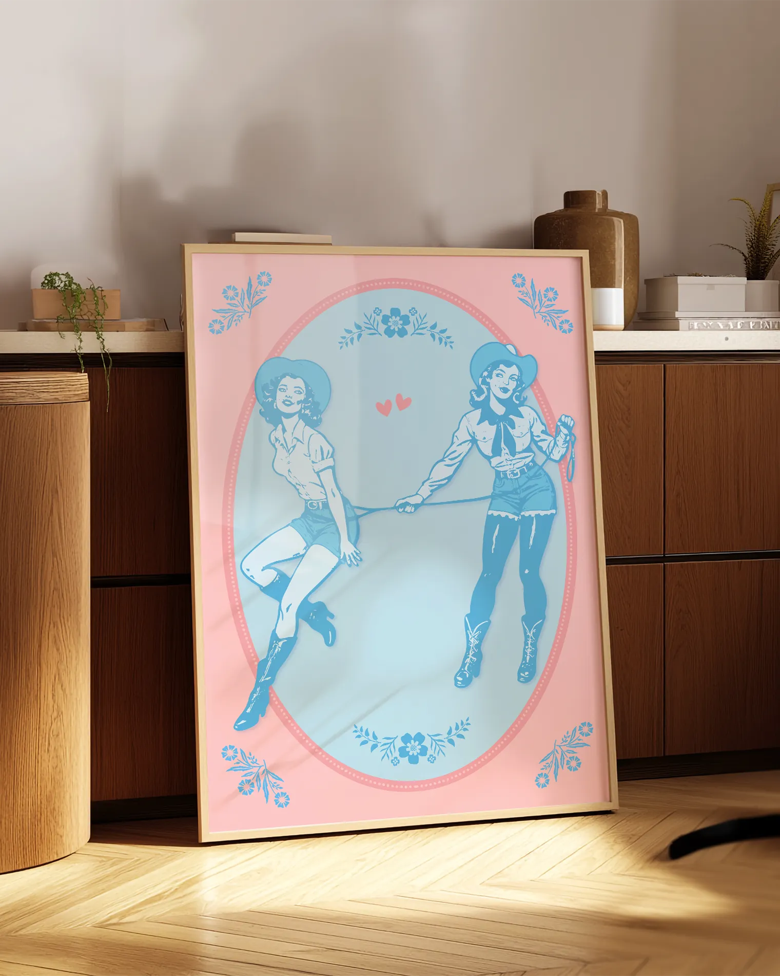 A poster with two illustrated cowgirls, catching each other with a lasso.