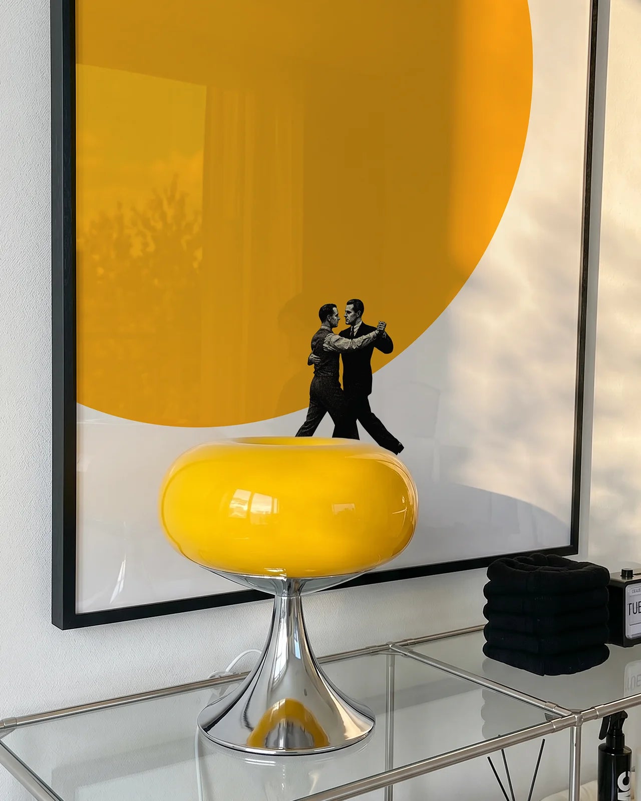 A poster of two men dancing in front of a big, yellow sun.