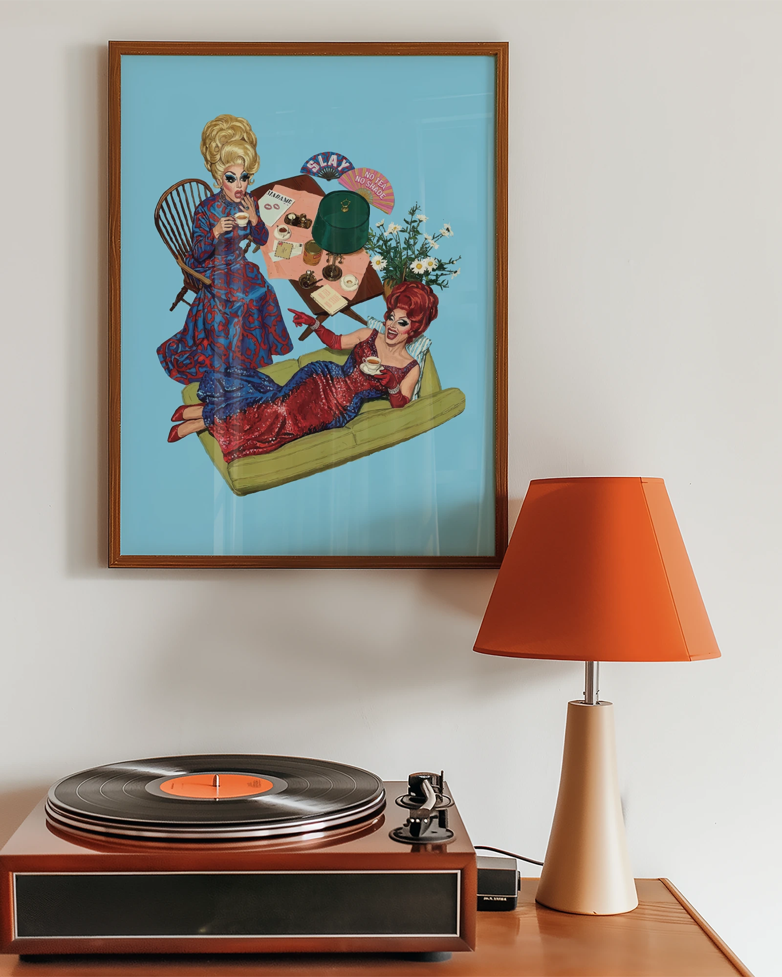 A framed print with two dragqueens spilling some tea, gossiping and laughing.