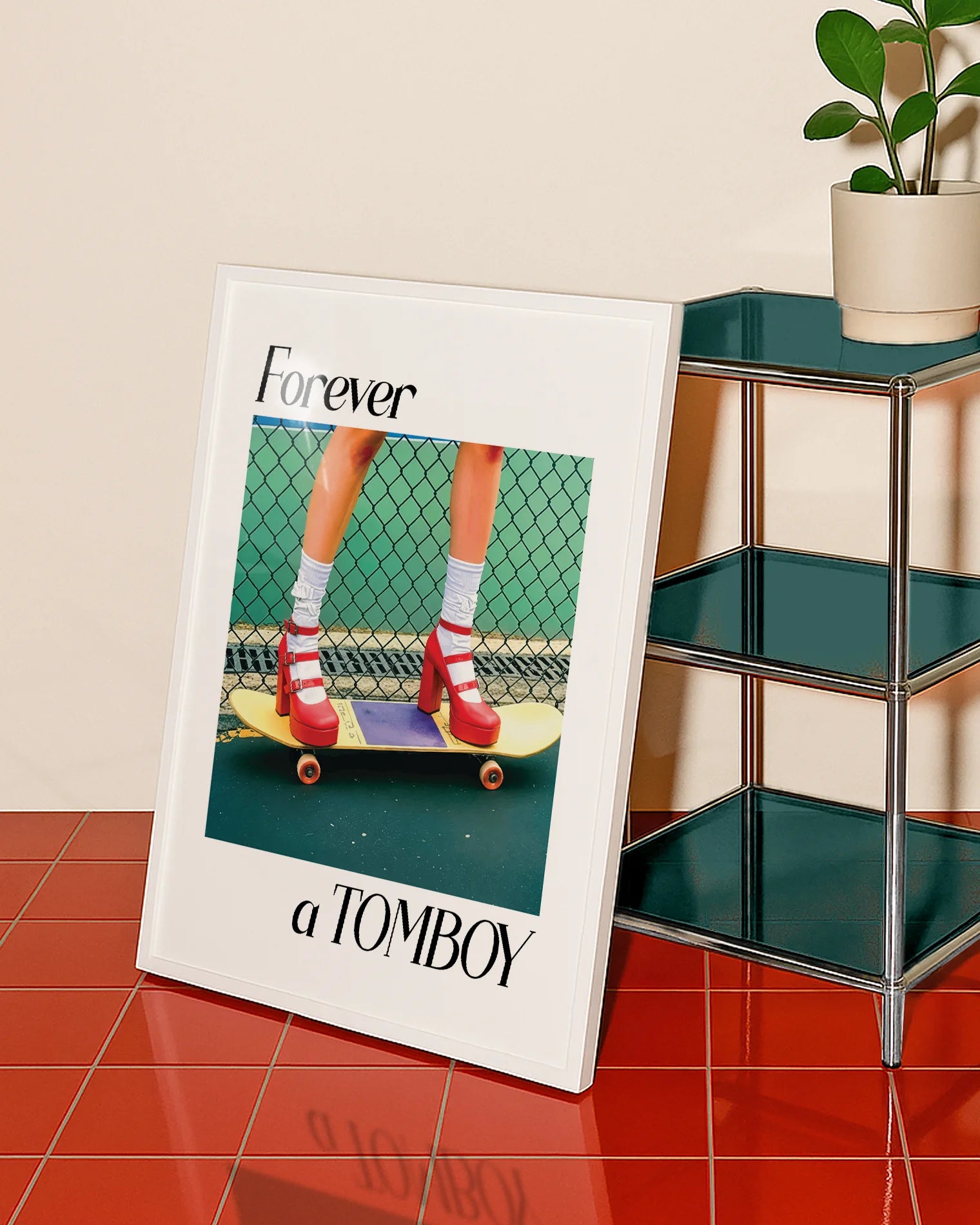 A framed print with a girl in red high heels standing on a skateboard, with the text: 'Forever a TOMBOY'.