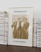 A print that shows three queer men in suits laughing together, with the text: “Heterosexuality? In this economy?”