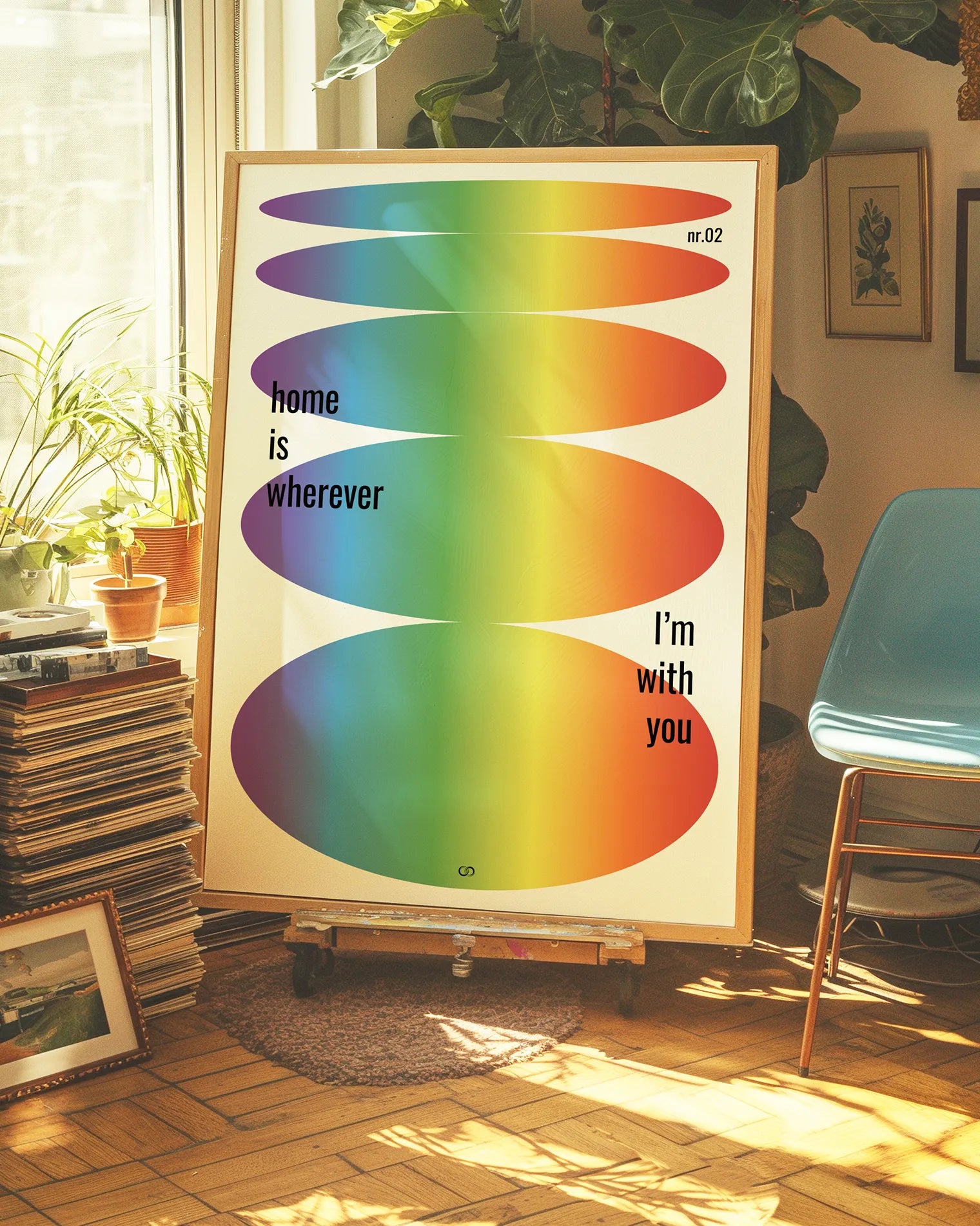 A retro inspired poster with oval forms in pride colours and text 'home is wherever I'm with you'.