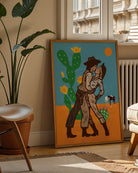 An illustrated print with a lesbian cowgirl couple kissing in the desert.
