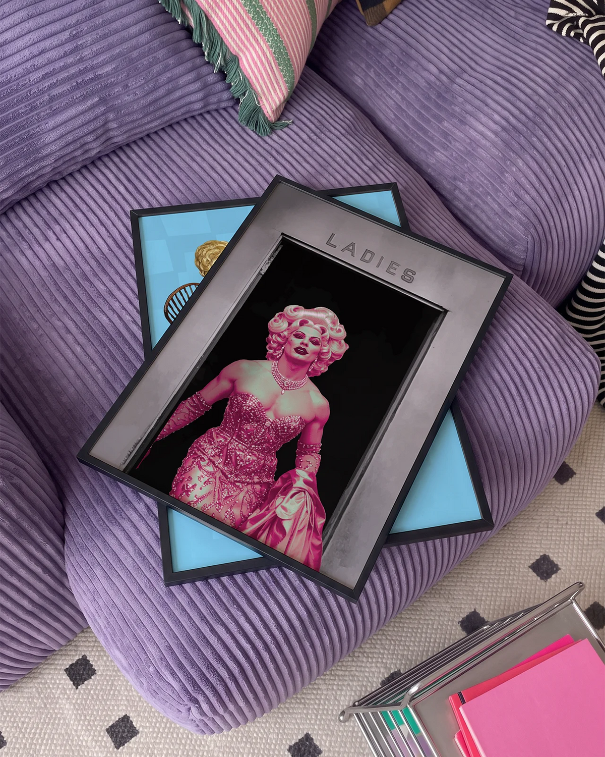 A poster with a muscular drag queen in a sparkling dress, full makeup, and wig, confidently strutting out of the ladies’ room.