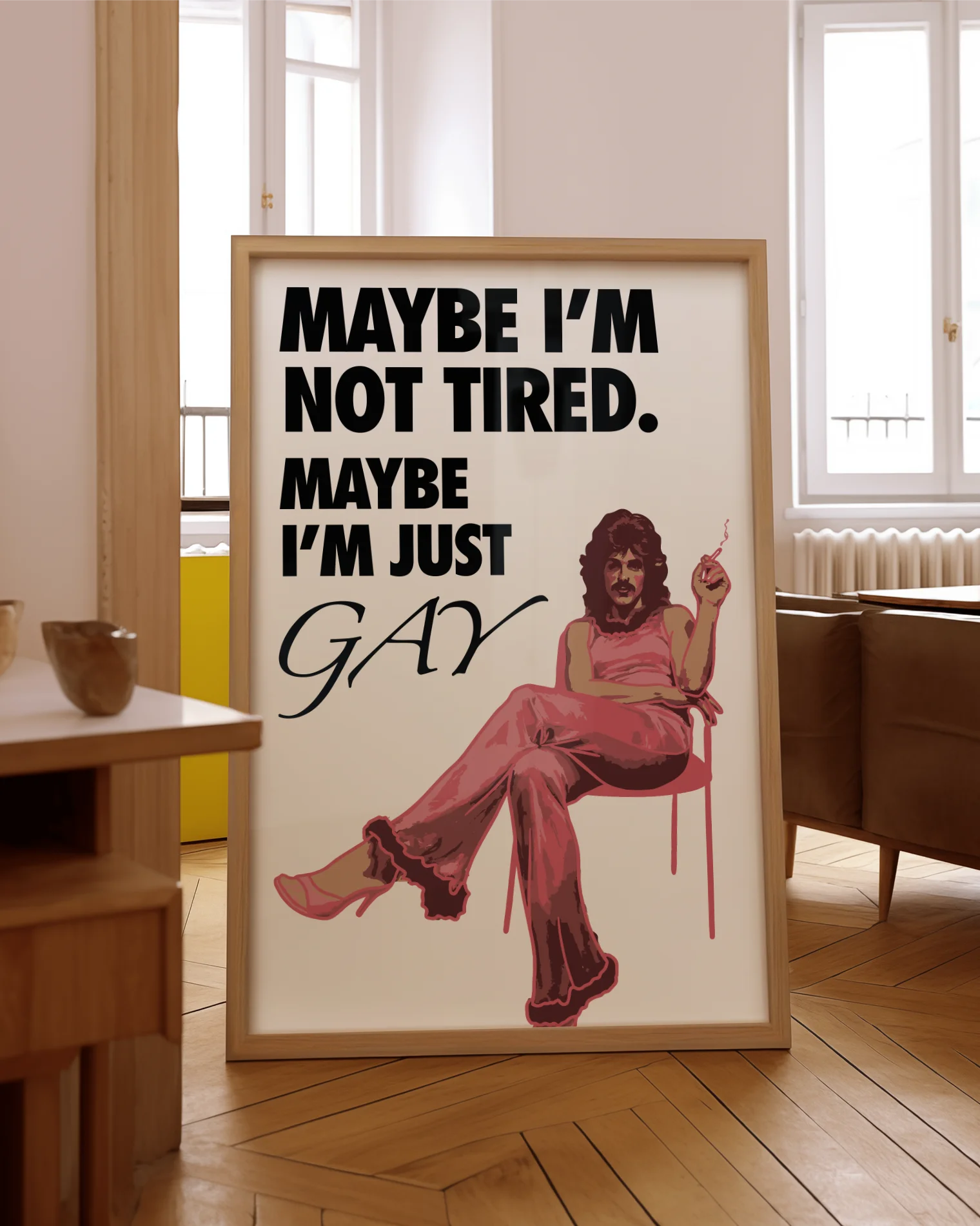 The poster features a fabulous person in pink clothing, heels and a 70s hairstyle with the text 'MAYBE I'M NOT TIRED. MAYBE I'M JUST GAY.'