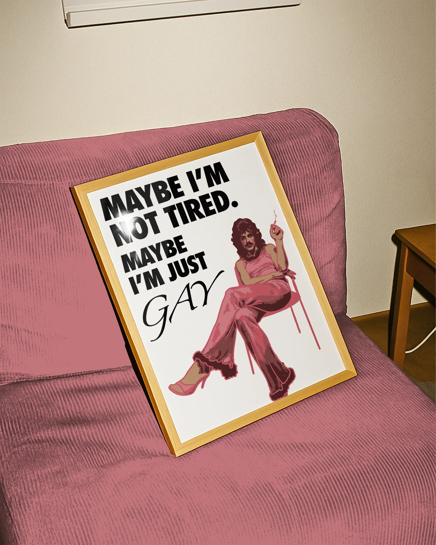 The poster features a fabulous person in pink clothing, heels and a 70s hairstyle with the text 'MAYBE I'M NOT TIRED. MAYBE I'M JUST GAY.'