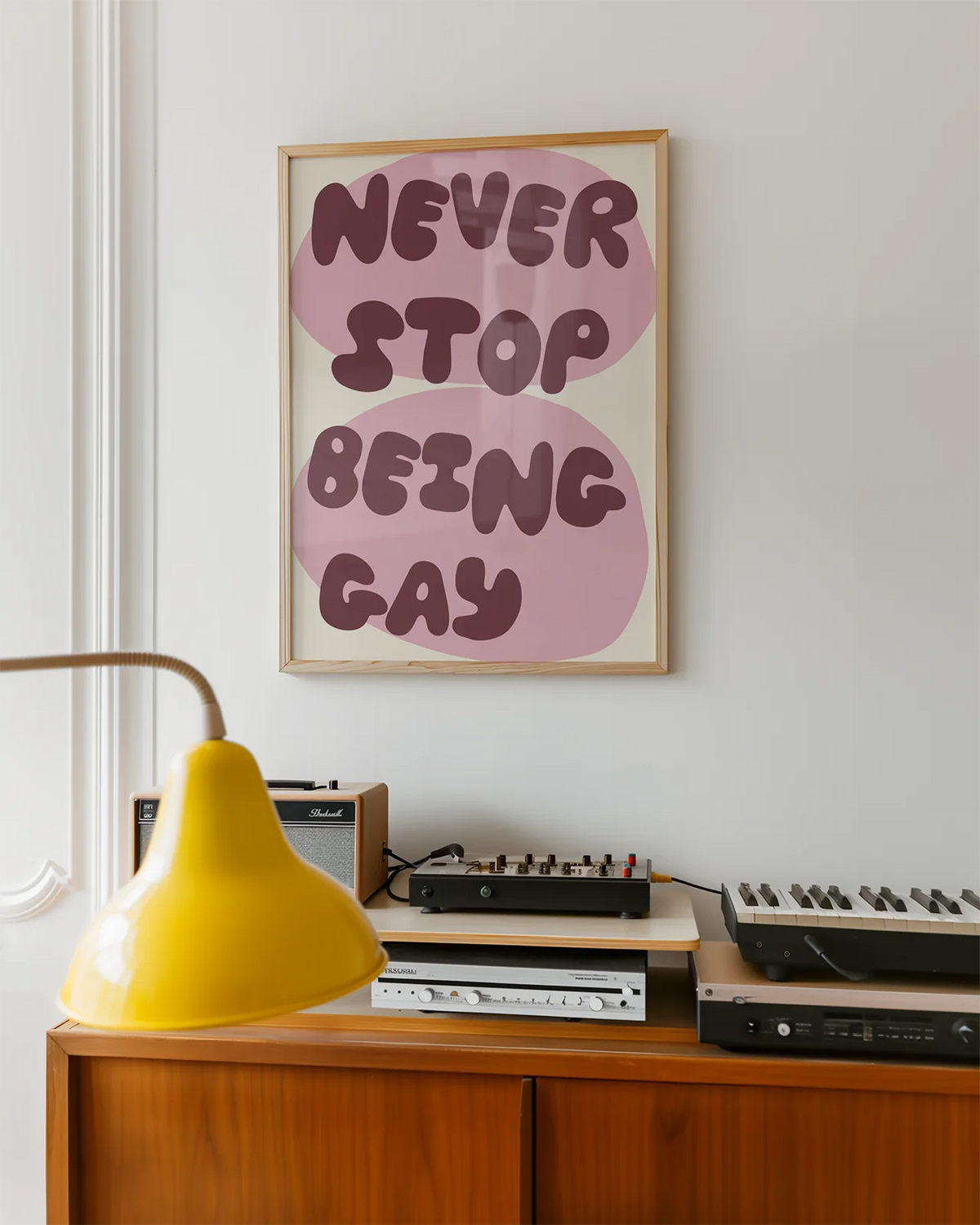 A poster with the text 'NEVER STOP BEING GAY'.