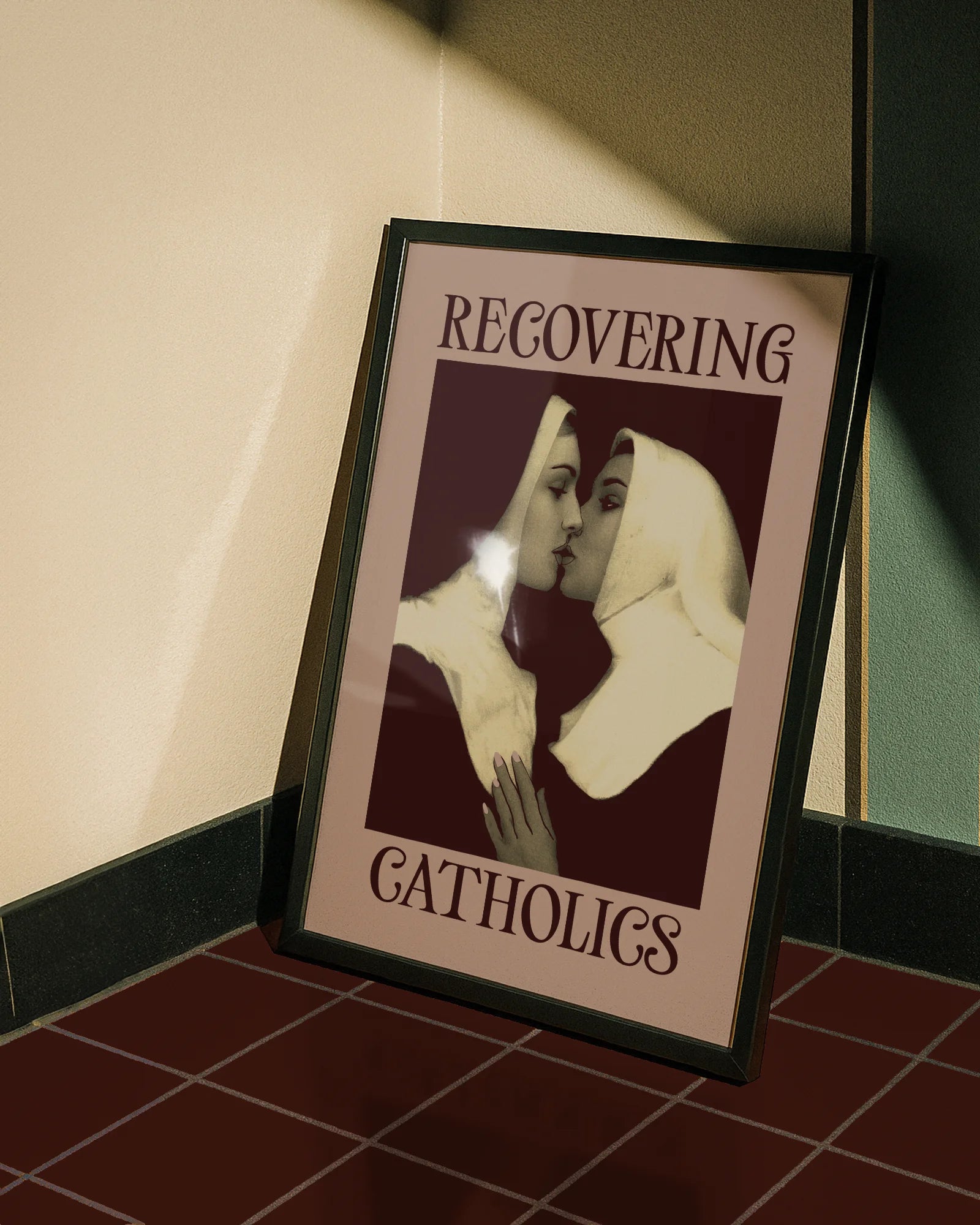 A framed poster featuring two kissing nuns, paired with the text "RECOVERING CATHOLICS."