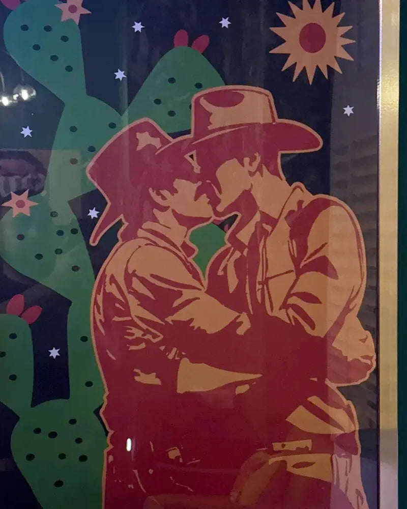 A review image from a customer of a framed print with two kissing cowboys.