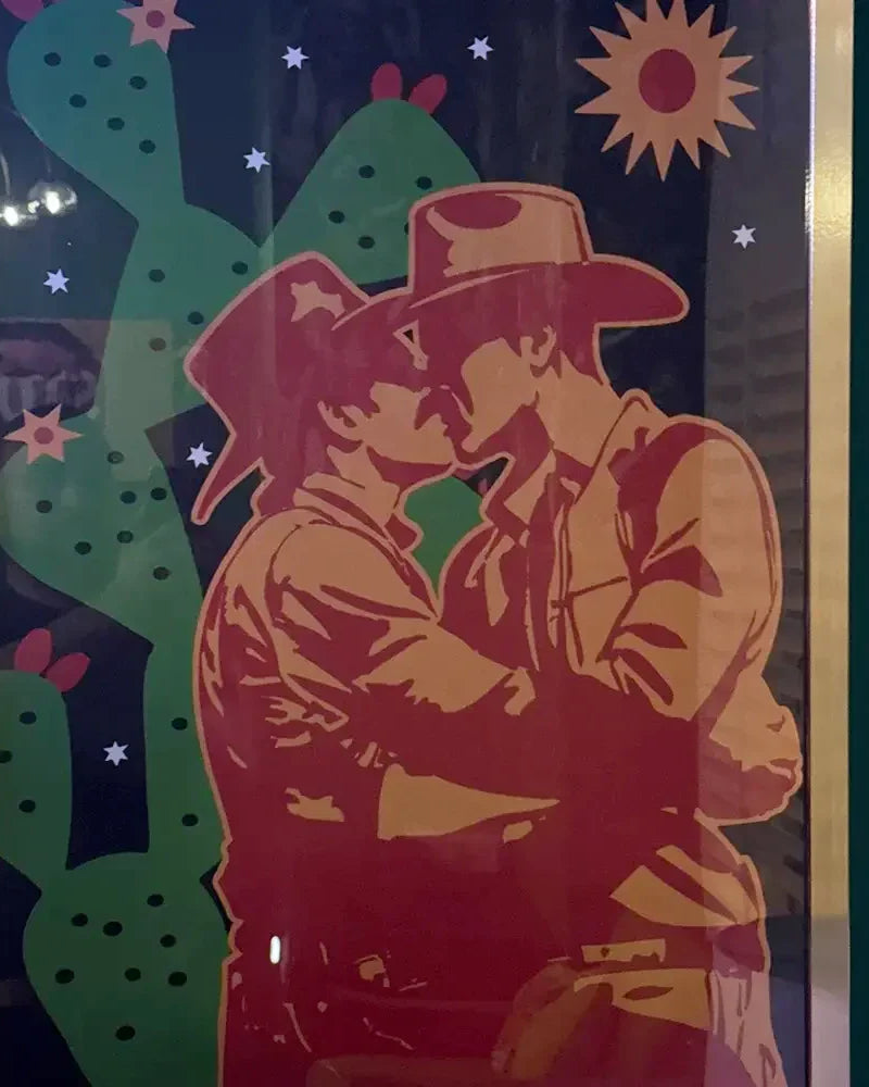 A review image from a customer of a framed print with two kissing cowboys.