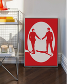 A print with an illustrated male couple in suits, walking hand in hand against a red background.