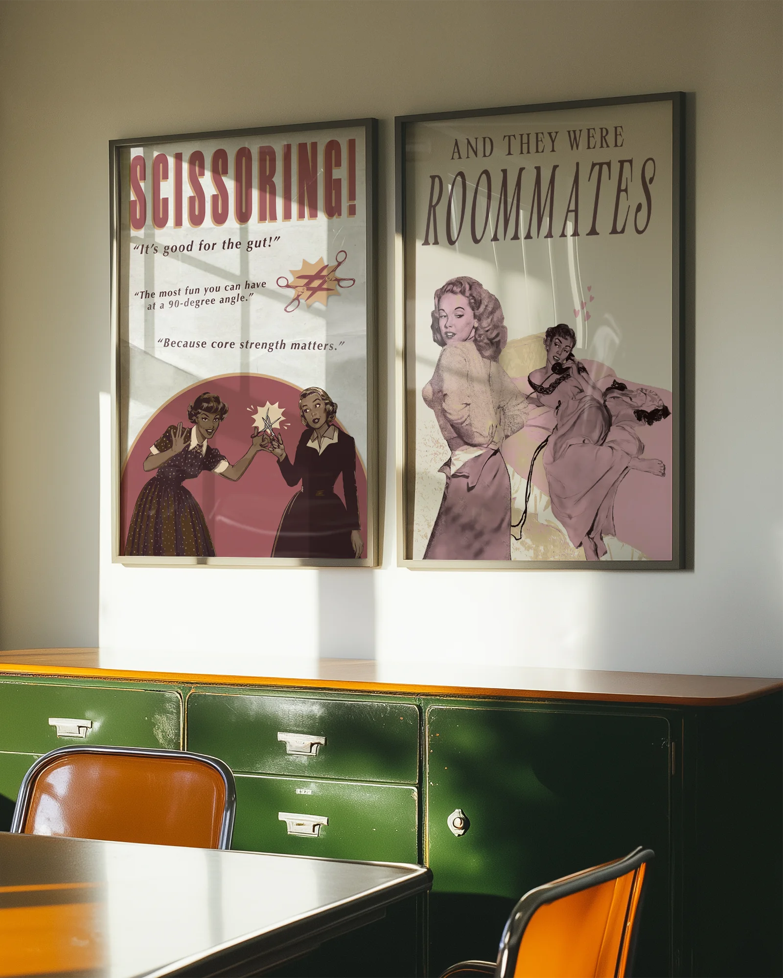 A framed poster depicting a woman lying in bed, and another woman undressing to join her — with the text “AND THEY WERE ROOMMATES.”