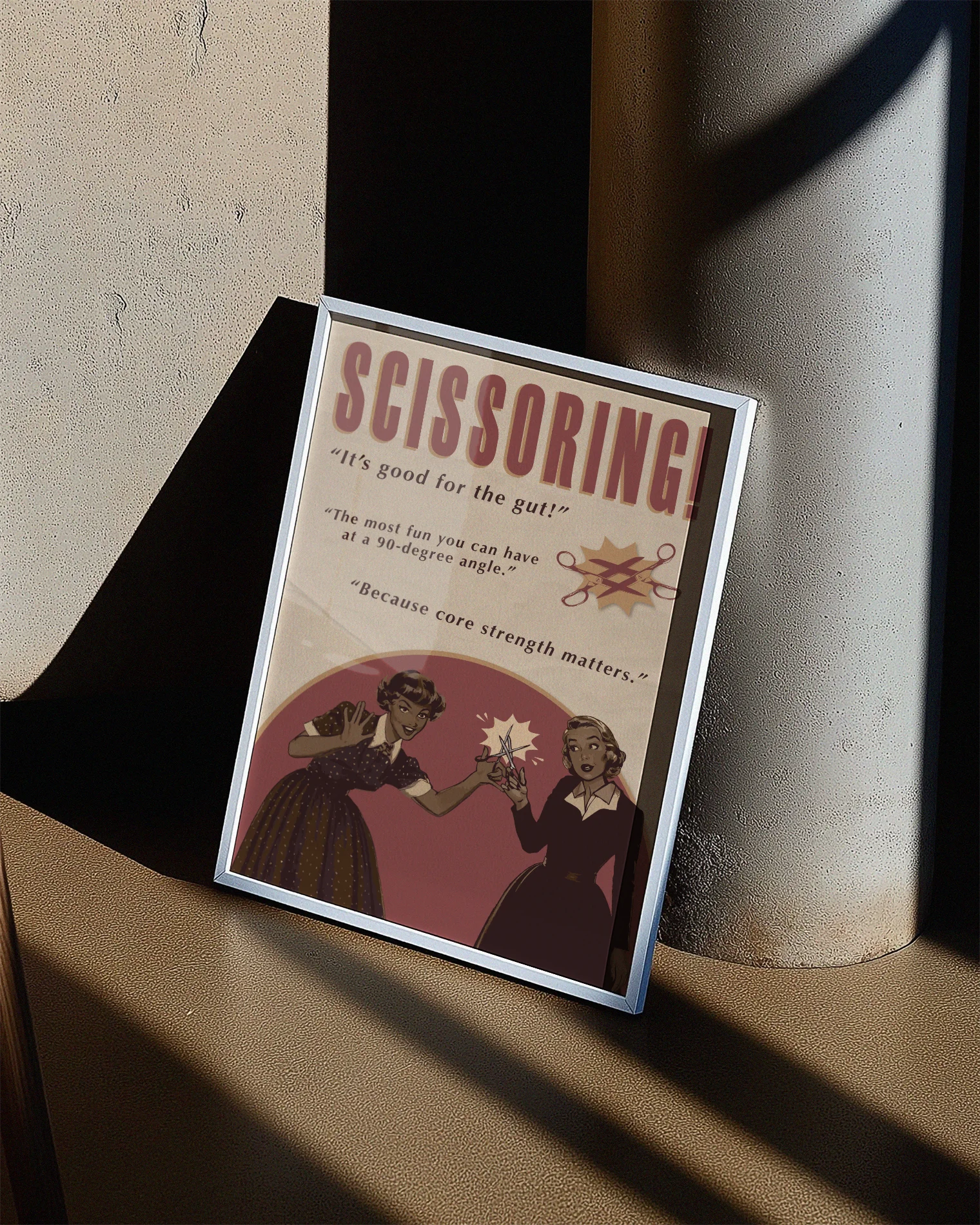 A print featuring two women playfully holding a pair of scissors toward each other, with the texts: “SCISSORING!”, “It’s good for the gut!”, “The most fun you can have at a 90-degree angle”, and “Because core strength matters.”