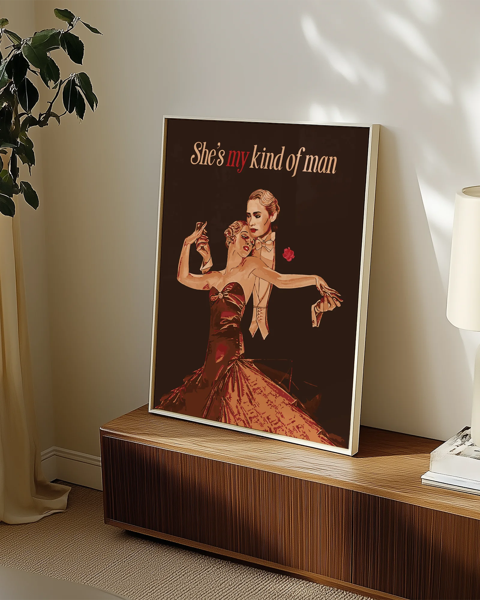 A framed print featuring a queer dancing couple in a vintage style, with the text: “She's my kind of man.”