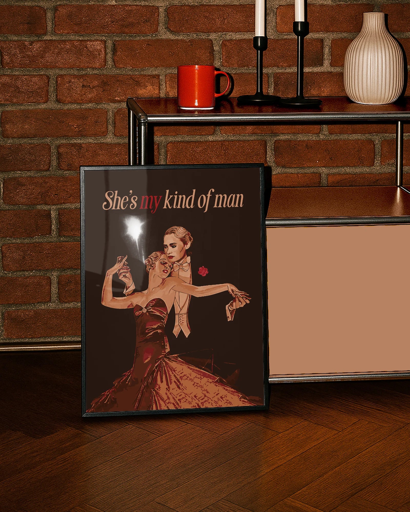 A framed print featuring a queer dancing couple in a vintage style, with the text: “She's my kind of man.”