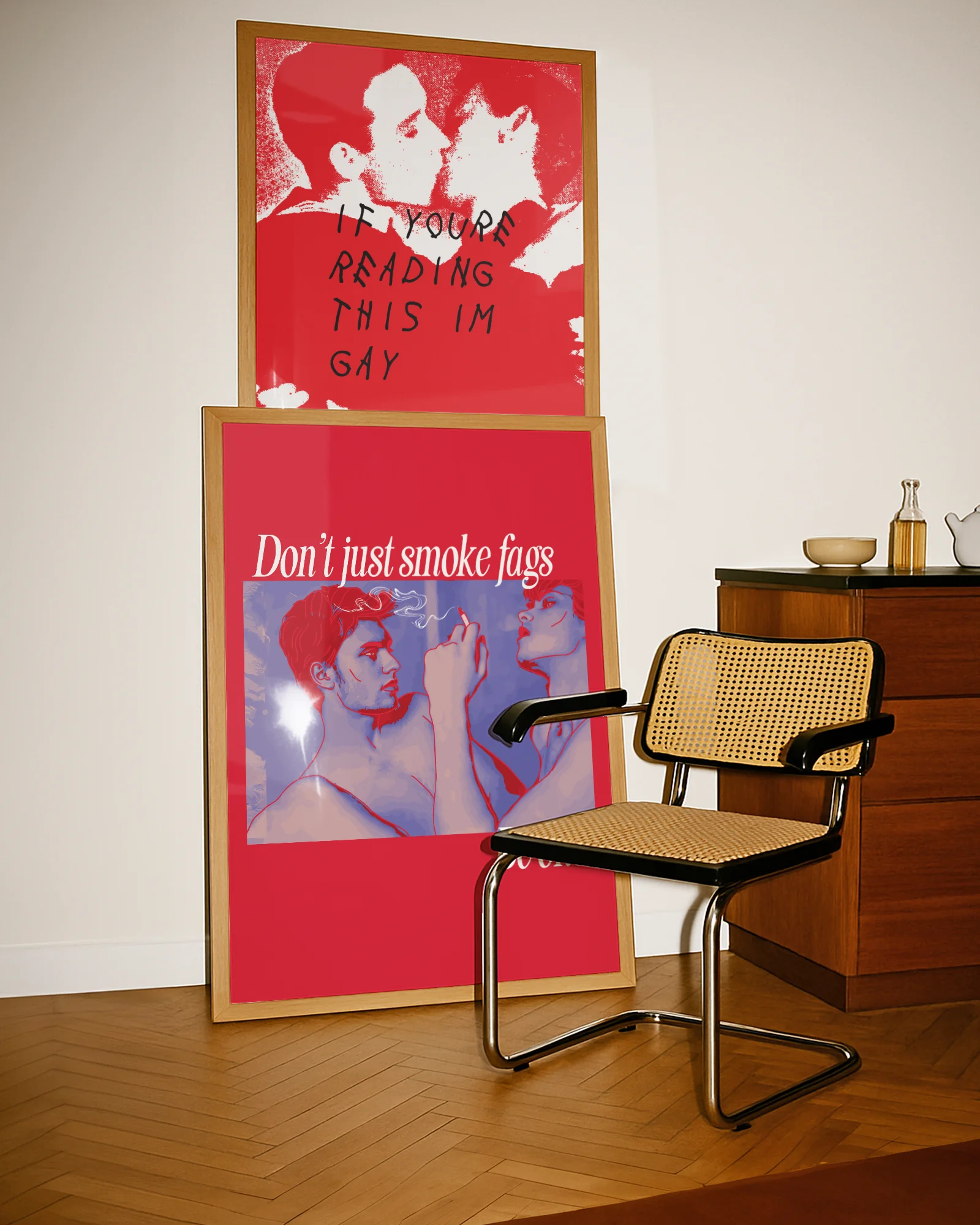 A framed poster shows two gay men, one of whom is smoking a cigarette, with the text: 'Don't just smoke fags — be one'.