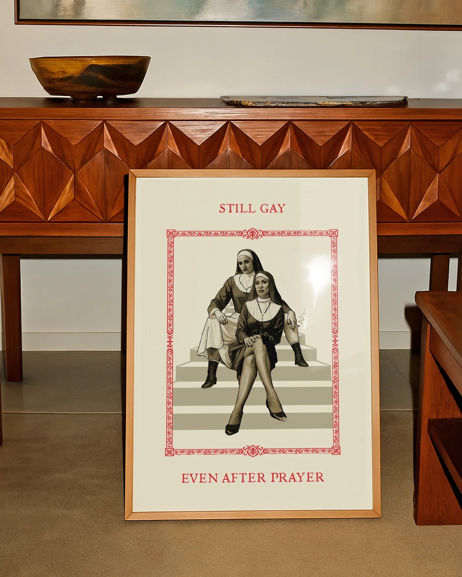 A poster featuring two rebellious nuns sitting on a staircase in a confident pose, with the text: “STILL GAY, EVEN AFTER PRAYER.”