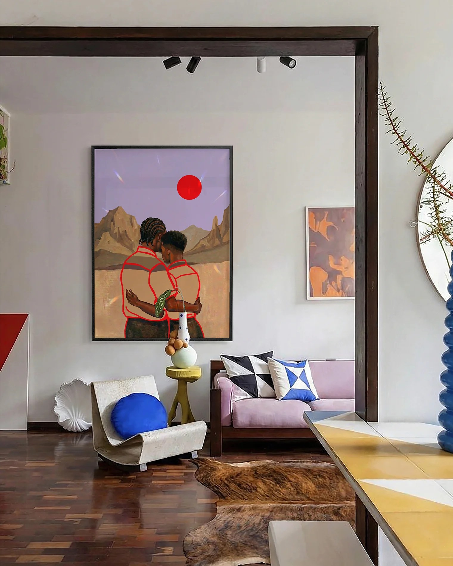 En poster som föreställer två män i en omfamning framför en vacker bergskedja, röd sol och lila himmel.