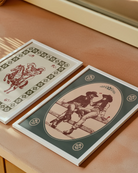 A print with an illustrated, sapphic cowgirl couple sitting on a fence.