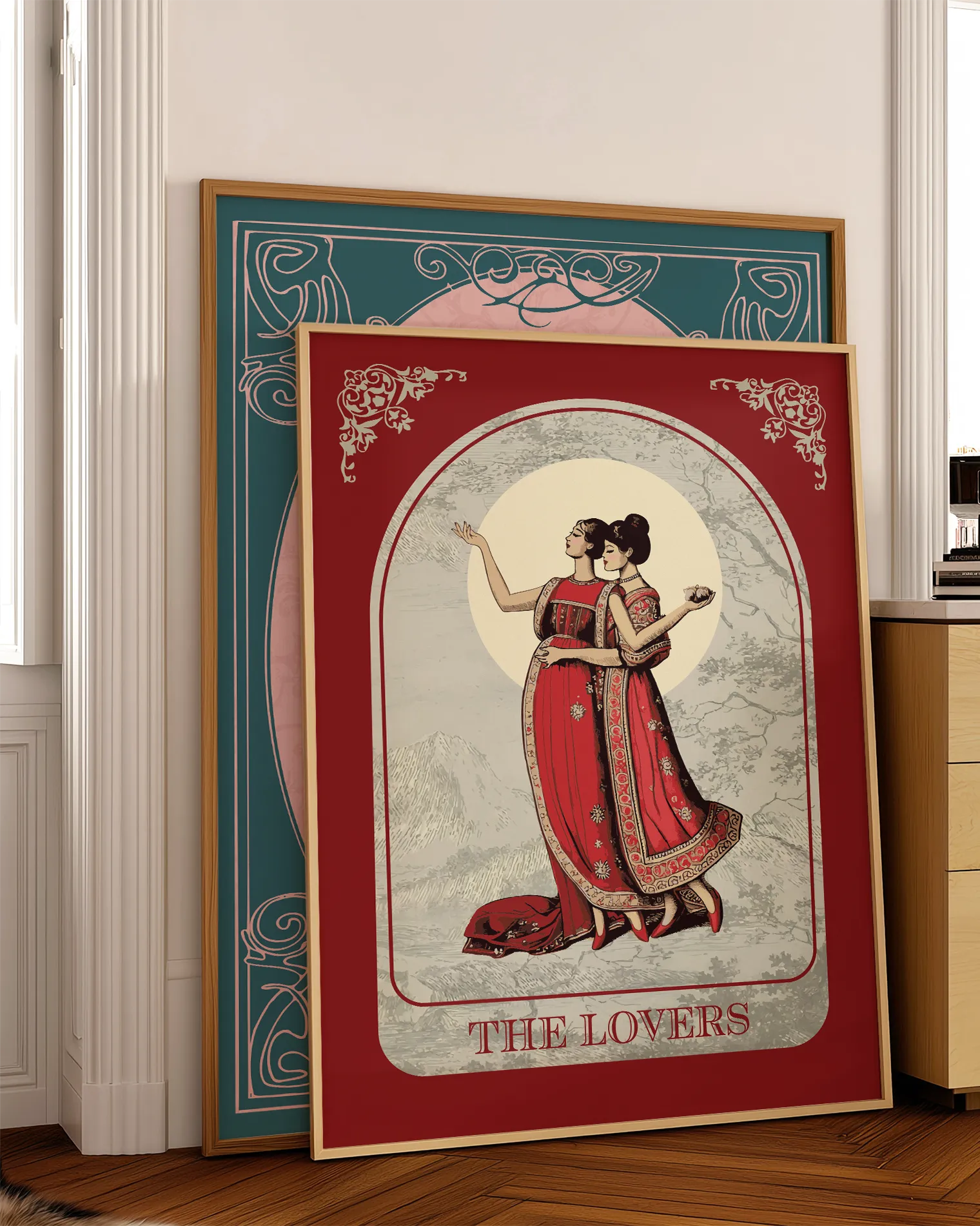 A poster with an illustrated, sapphic couple in the 1700's, posing in red dresses with the text 'The Lovers'.