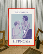 A poster with a woman staring unabashedly and fascinated at another woman’s chest, with the text: ‘THE POWER OF HYPNOSIS.