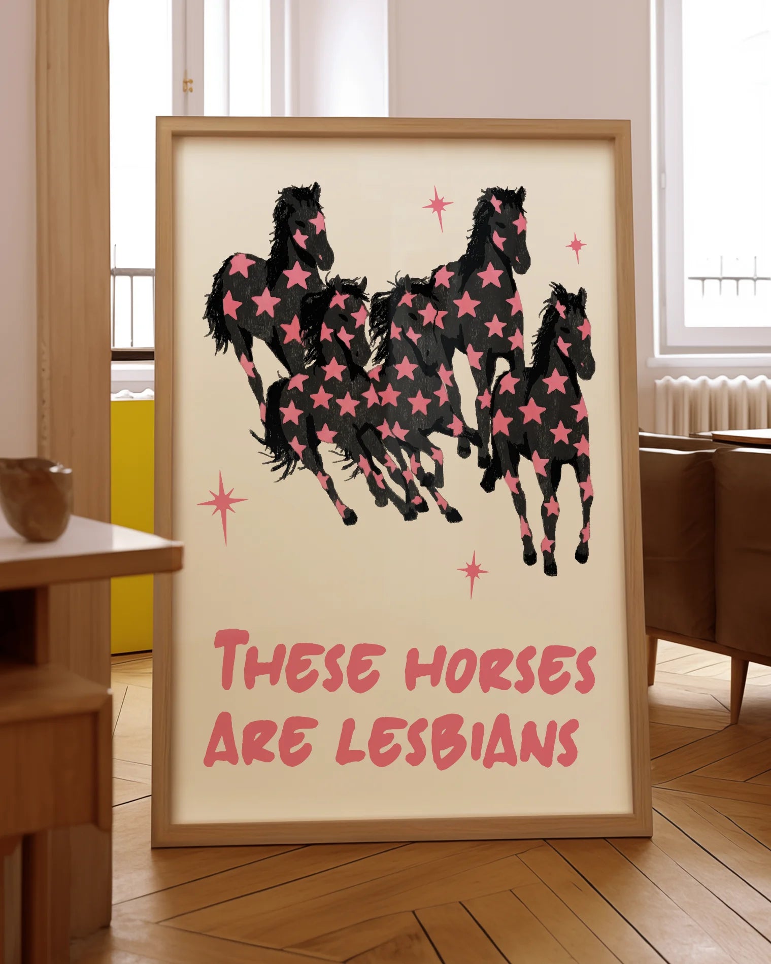A framed poster with five horses and the text 'THESE HORSES ARE LESBIANS'.