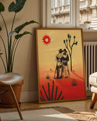 A print with an illustrated cowboys-couple in a desert, surrounded by a red and yellow sunset.