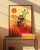 A print with an illustrated cowboys-couple in a desert, surrounded by a red and yellow sunset.