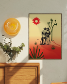 A print with an illustrated cowboys-couple in a desert, surrounded by a red and yellow sunset.