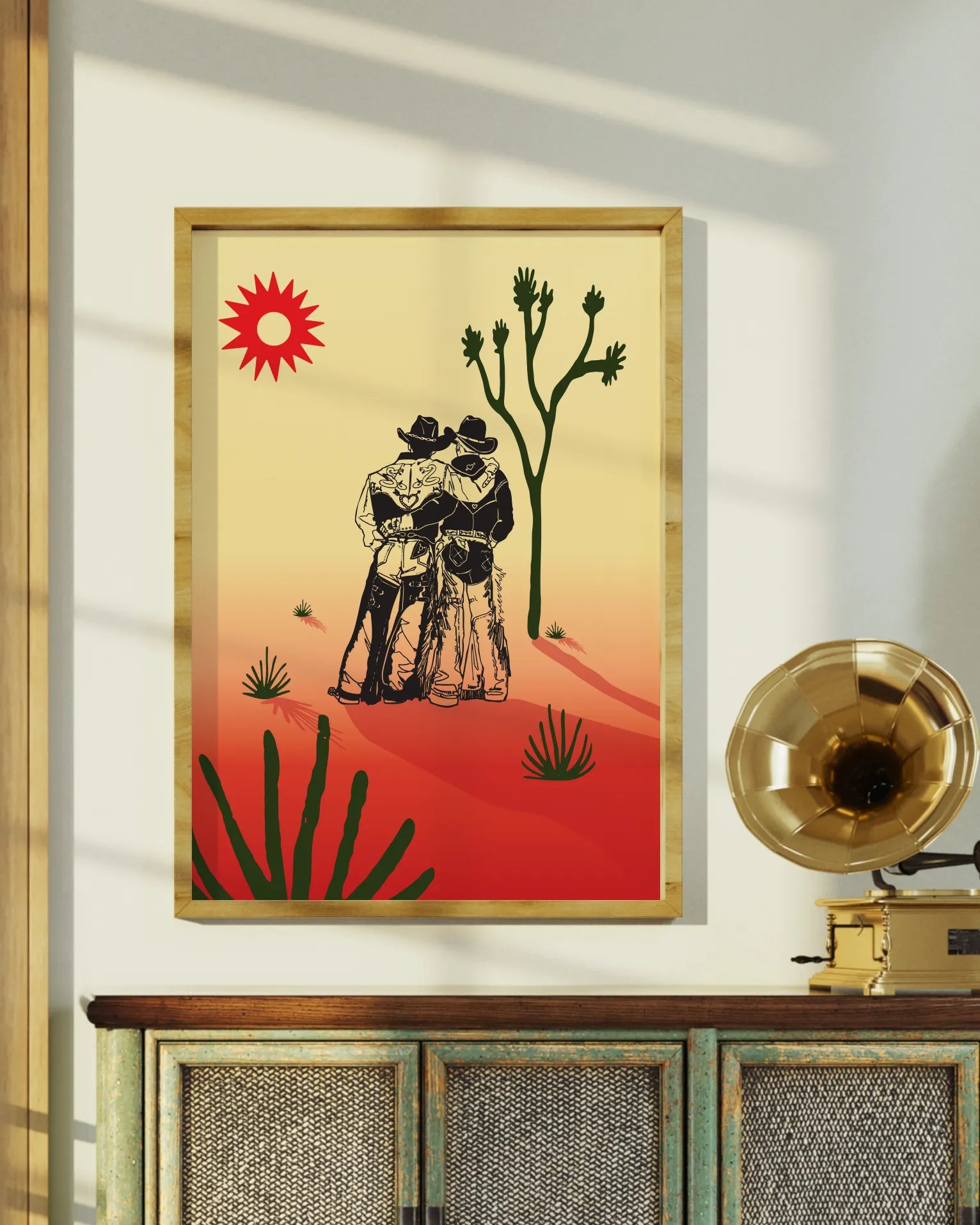 A print with an illustrated cowboys-couple in a desert, surrounded by a red and yellow sunset.