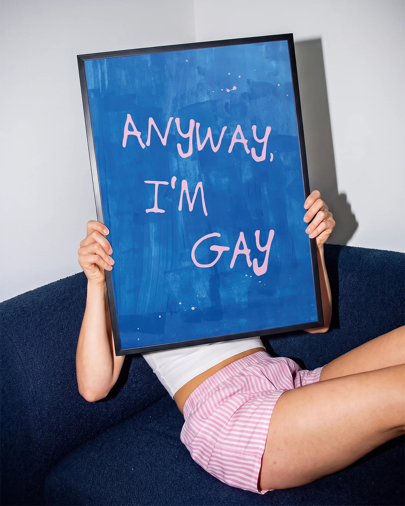 A poster with the text 'ANYWAY, I'M GAY' in pink, against a blue abstract background.