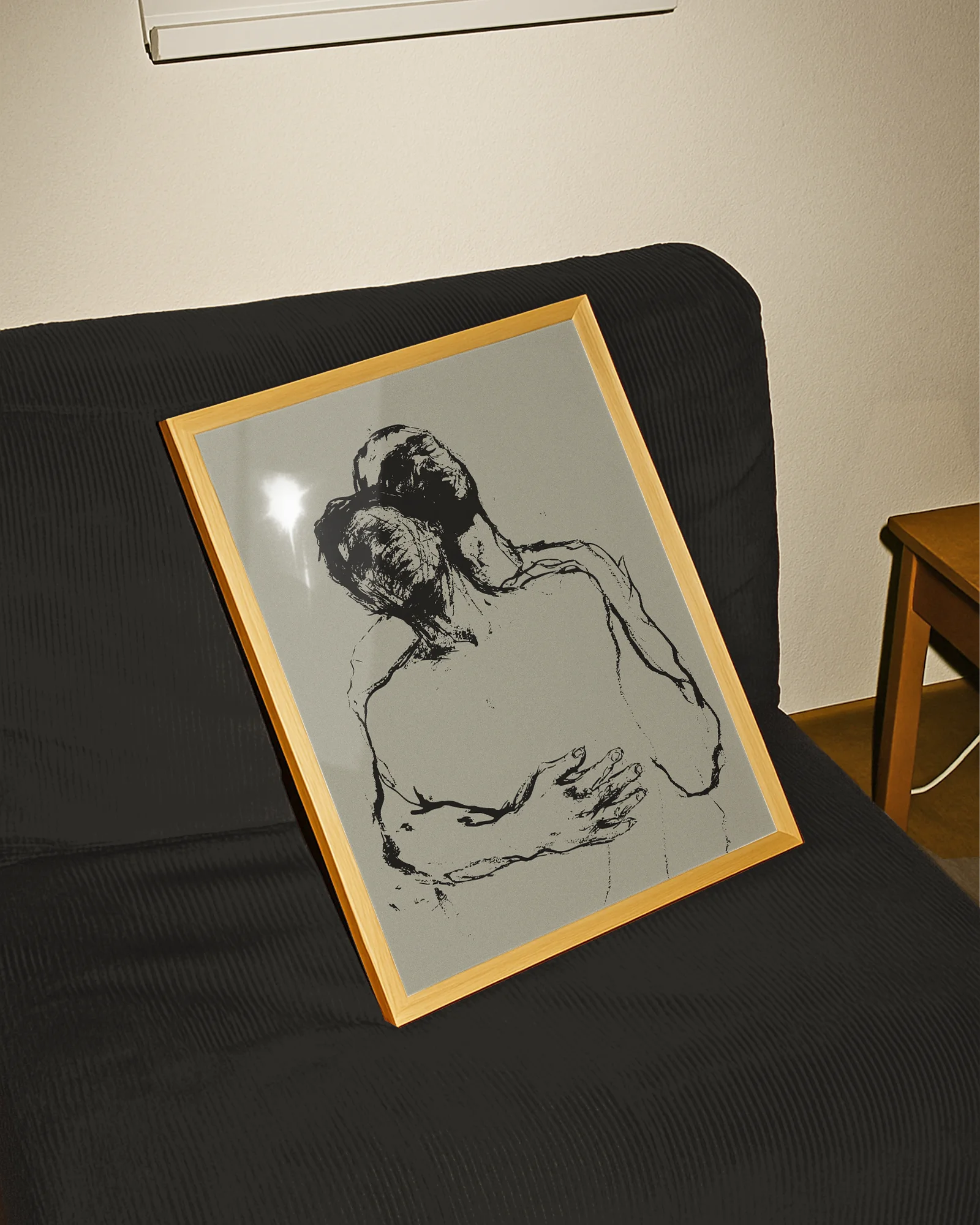 A framed poster with two, sketched gay men embracing in a dramatic pose.