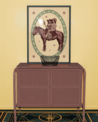 A framed poster featuring two lesbian cowgirls sitting on a horse, surrounded by a retro-style floral frame.