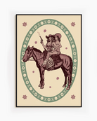 A framed poster featuring two lesbian cowgirls sitting on a horse, surrounded by a retro-style floral frame.