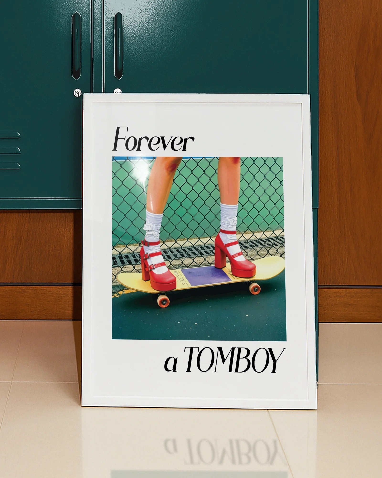 A framed print with a girl in red high heels standing on a skateboard, with the text: 'Forever a TOMBOY'.