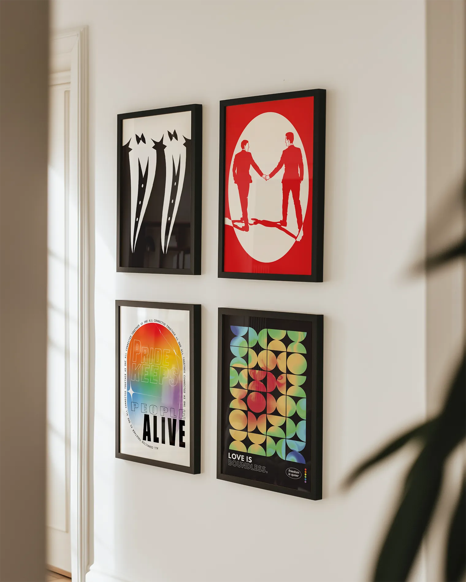 A gallery wall with four pride themed prints.