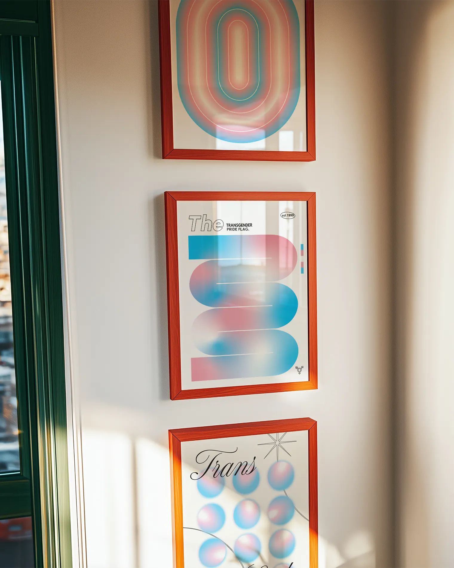 A gallery wall with three transgender themed prints.