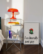 A framed poster with a cute, green, smoking frog with the text 'I´m literally just gay'.