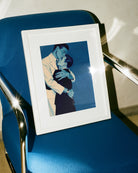 A framed print with two gay men hugging tightly, vintage 1940's style.