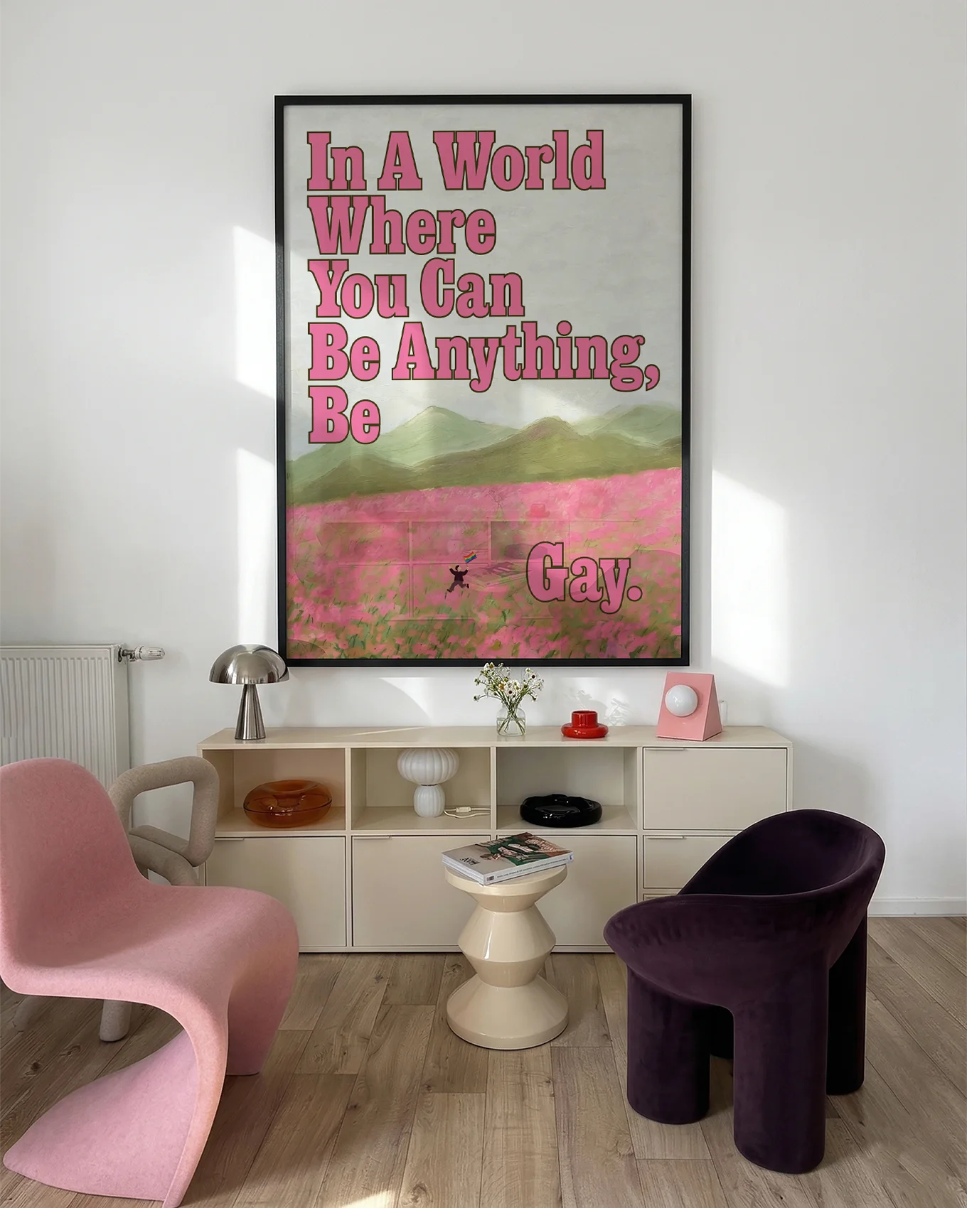 A poster of a person running through an open field of pink flowers, with a pride flag and the text: 'In a world where you can be anything, be gay'.