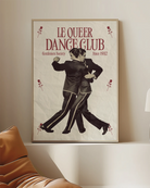 A framed print depicting two dancing gay men in a vintage, retro style, featuring the text “LE QUEER DANCECLUB” and “Gentlemen Society Since 1932.”