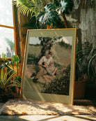 A framed poster with two men cuddling in a park. Vintage, oil painting style.