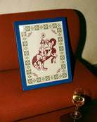 A framed poster with two, naked cowgirls riding a horse.