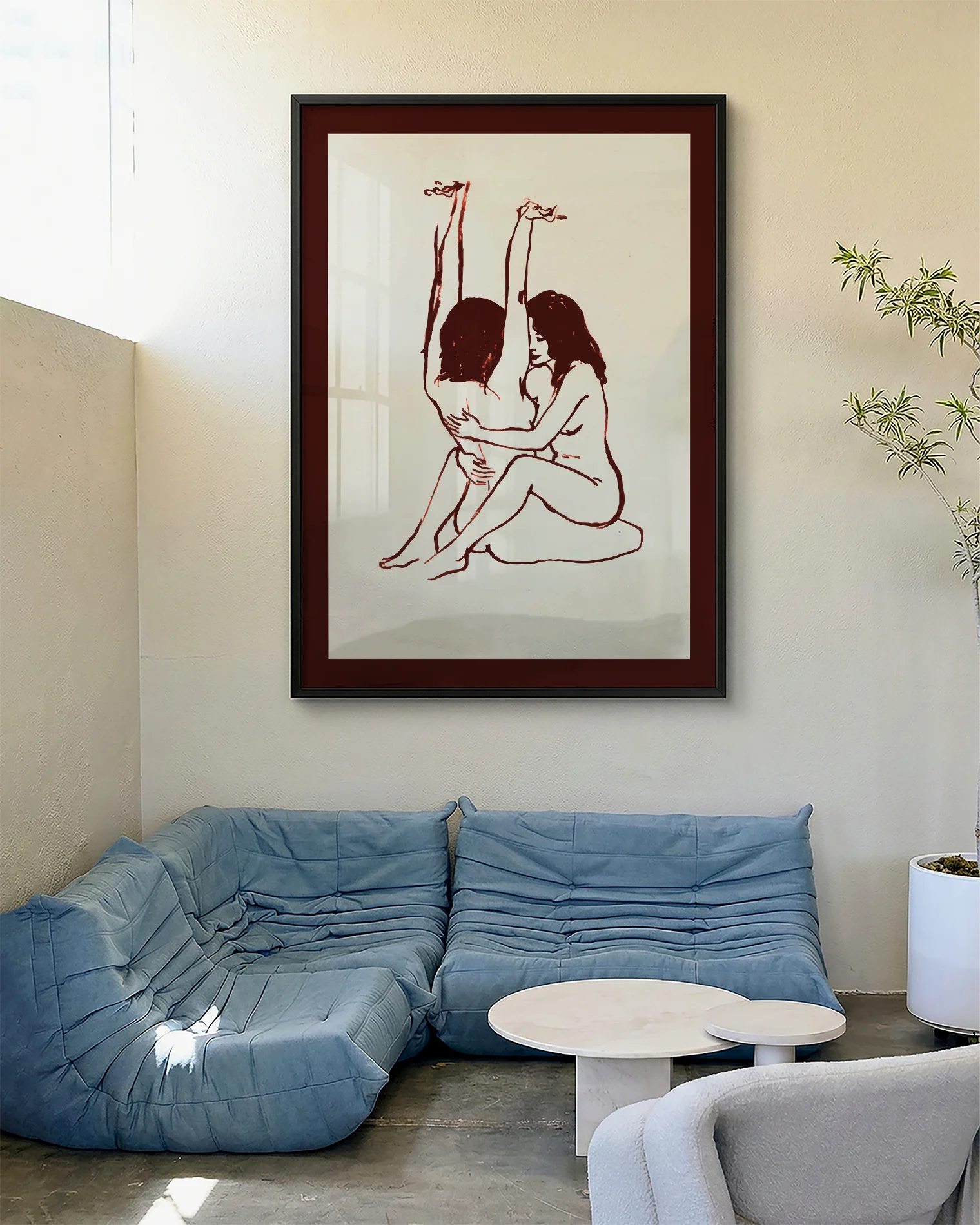 A framed print with two naked girls, hugging tight on the floor.