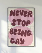 A poster with the text 'NEVER STOP BEING GAY'.
