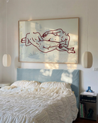 A framed poster with two lesbian girls laying down.