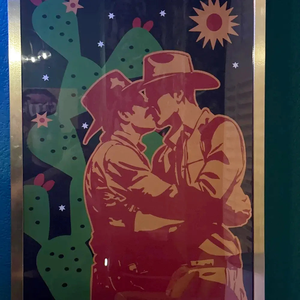 A review image from a customer of a framed print with two kissing cowboys.