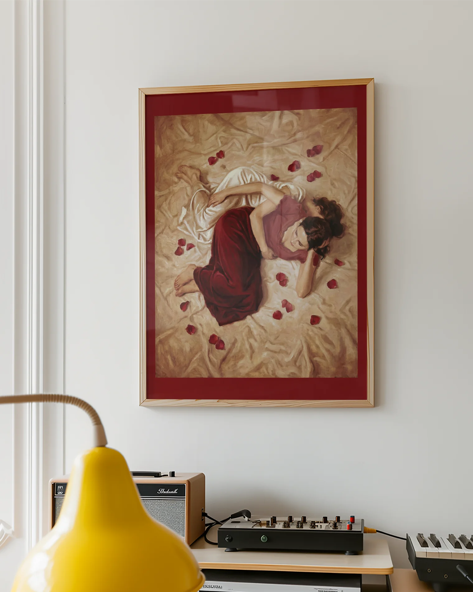 A framed poster with two sapphic ladies in a bed, surrounded by rose pedals.